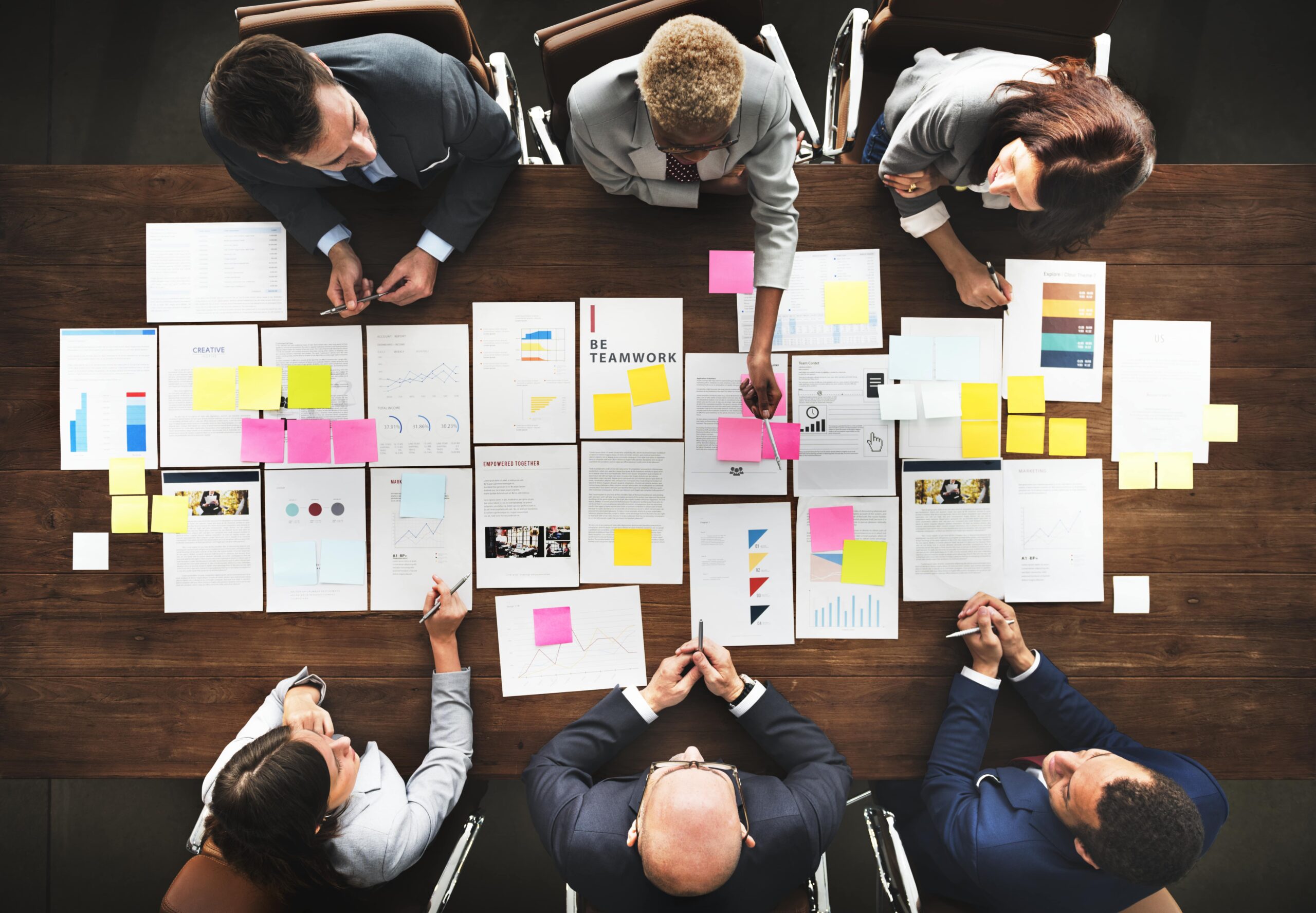 Groupe de professionnels autour d’une table, analysant des documents et post-its colorés pour comparer les statuts juridiques entreprise france.